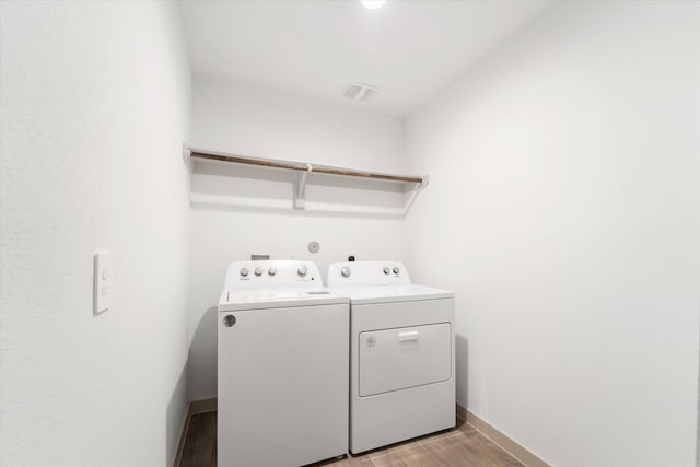 washroom with washer and clothes dryer and light hardwood / wood-style floors