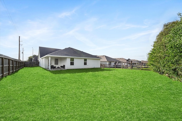 back of house with a yard and a patio