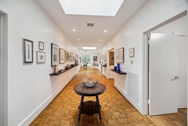 hall with a skylight and light parquet flooring