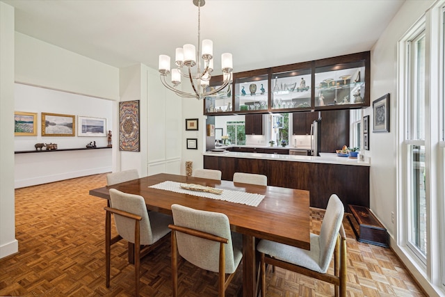 dining area with parquet flooring and a notable chandelier