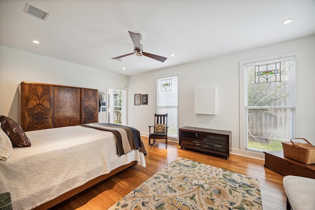 bedroom with light hardwood / wood-style floors, multiple windows, and ceiling fan