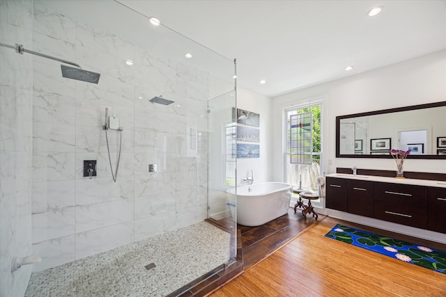 bathroom with hardwood / wood-style floors, vanity, and separate shower and tub