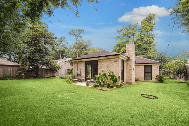 back of house with a yard and a patio