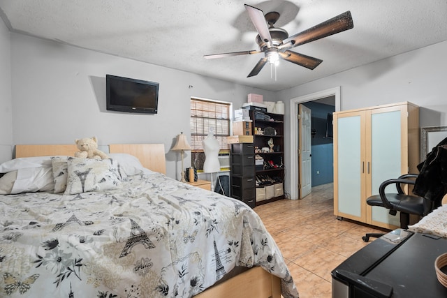 tiled bedroom featuring ceiling fan and a textured ceiling