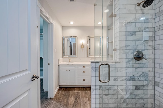 bathroom with vanity, wood-type flooring, and an enclosed shower