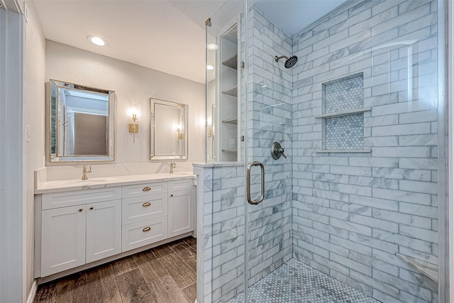 bathroom with vanity, hardwood / wood-style flooring, and a shower with shower door