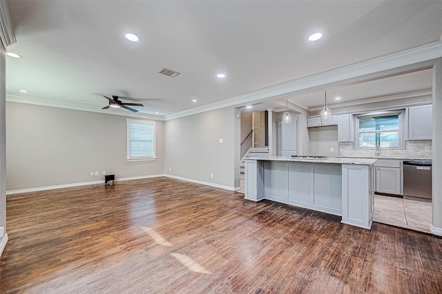 kitchen with appliances with stainless steel finishes, crown molding, wood-type flooring, a kitchen island, and hanging light fixtures