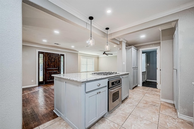 kitchen with light stone counters, ornamental molding, stainless steel appliances, and light hardwood / wood-style floors