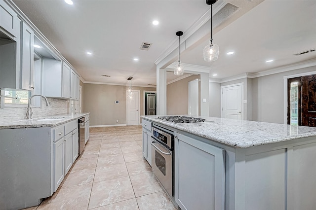 kitchen featuring stainless steel appliances, a kitchen island, ornamental molding, and sink