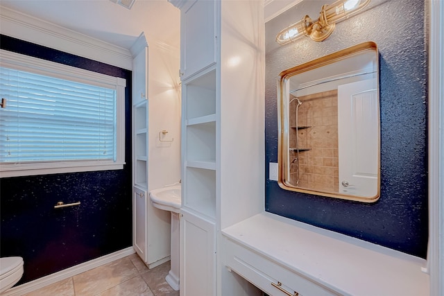 bathroom featuring tile patterned flooring, tiled shower, toilet, and crown molding