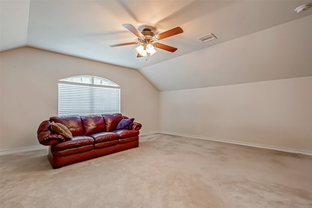 carpeted living room with ceiling fan and vaulted ceiling