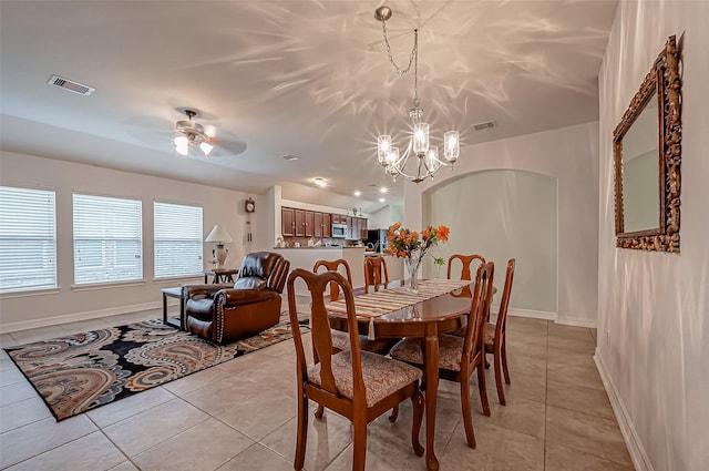 dining space featuring visible vents, baseboards, light tile patterned flooring, and ceiling fan with notable chandelier