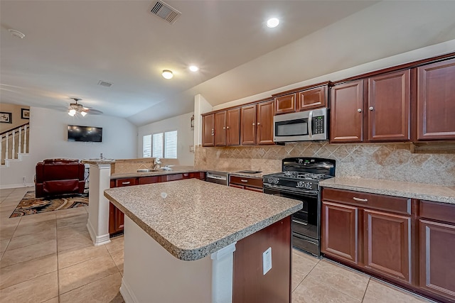 kitchen with light tile patterned floors, visible vents, lofted ceiling, black range with gas stovetop, and stainless steel microwave