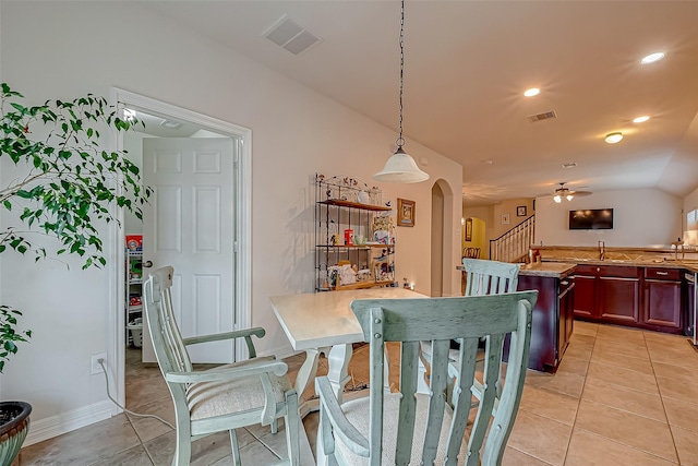 dining room featuring light tile patterned floors, visible vents, arched walkways, and stairway