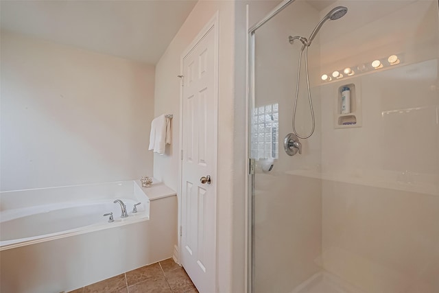 full bathroom featuring tile patterned flooring, a bath, and a stall shower