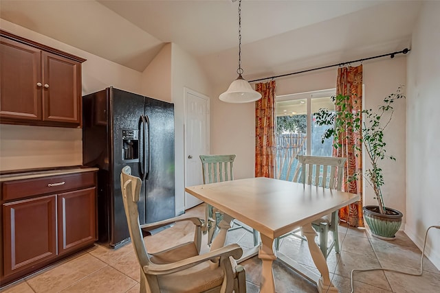 dining area with lofted ceiling and light tile patterned flooring