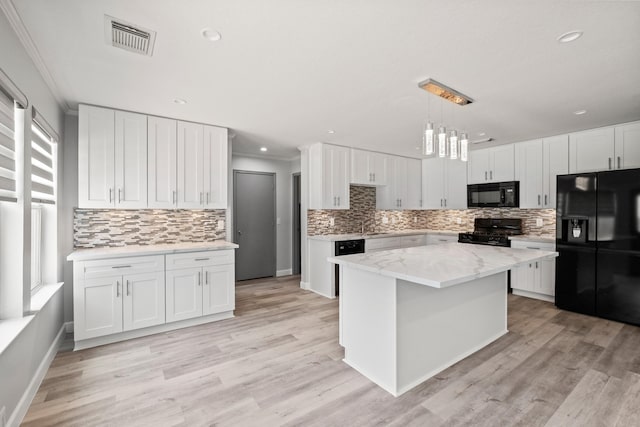 kitchen featuring ornamental molding, white cabinets, black appliances, and a kitchen island