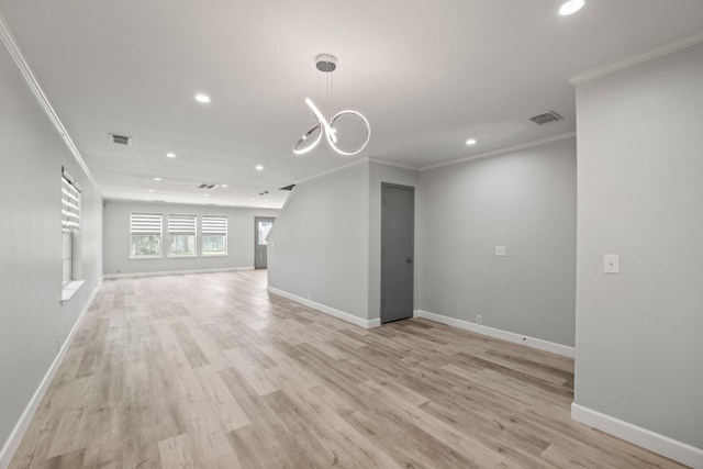 unfurnished living room featuring crown molding, light hardwood / wood-style flooring, and a notable chandelier