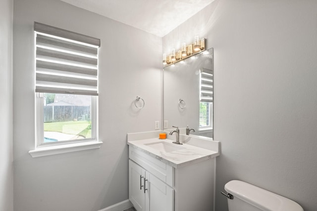 bathroom featuring vanity, toilet, and a wealth of natural light