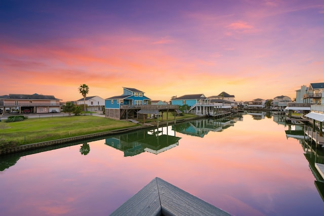 dock area with a lawn and a water view