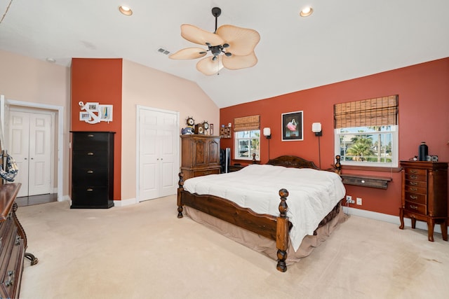 bedroom featuring ceiling fan, vaulted ceiling, light colored carpet, and a closet