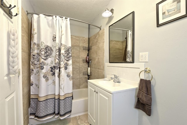 bathroom with shower / bath combo with shower curtain, vanity, and a textured ceiling