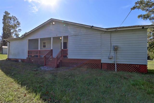 rear view of house featuring a lawn