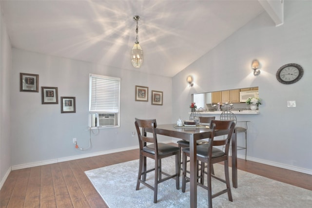 dining space featuring hardwood / wood-style flooring, cooling unit, and vaulted ceiling