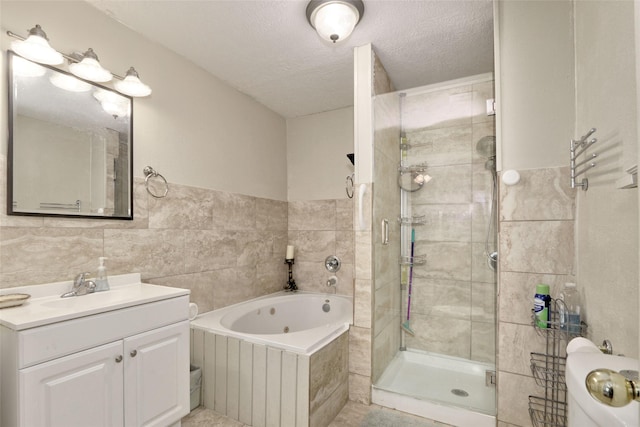 bathroom with vanity, a textured ceiling, and tile walls