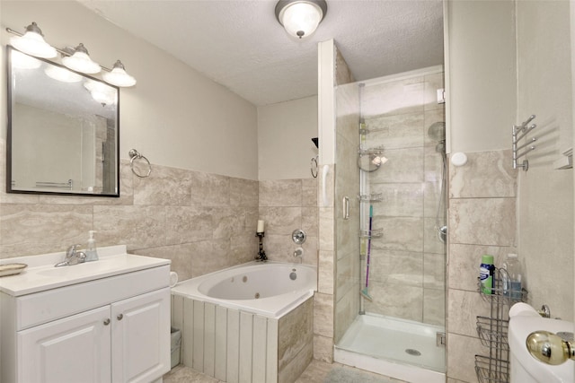 170 Mesa Verde, Livingston, TX 77351 - full bath with a textured ceiling, a stall shower, vanity, tile walls, and a whirlpool tub