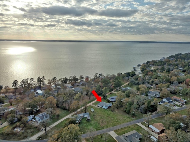 aerial view at dusk featuring a water view