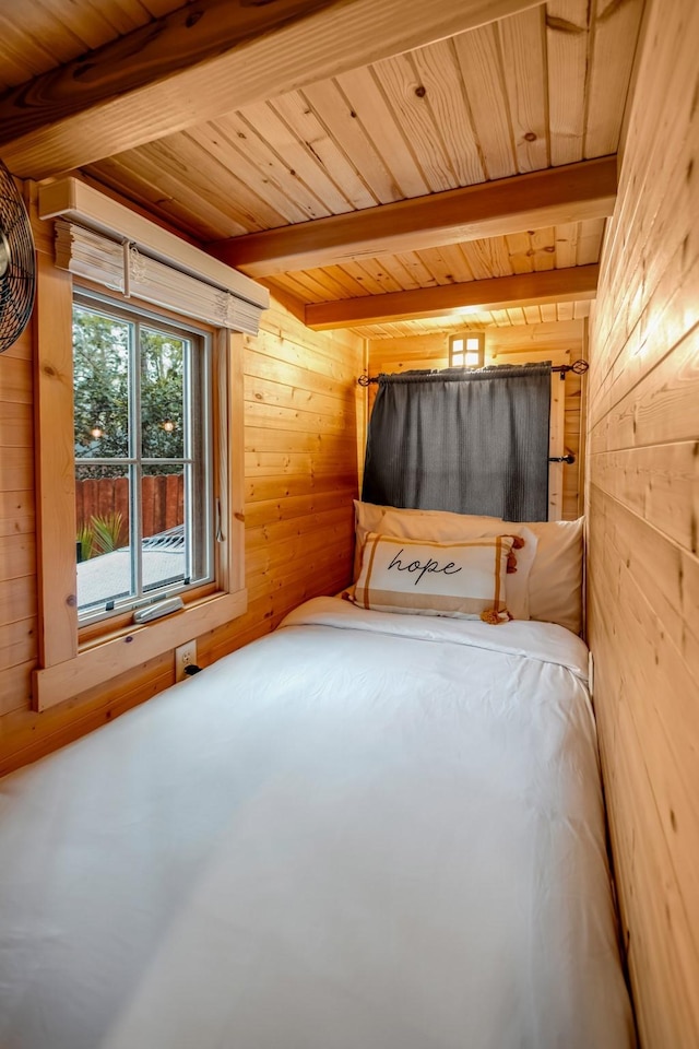 unfurnished bedroom featuring beamed ceiling, wooden ceiling, and wooden walls