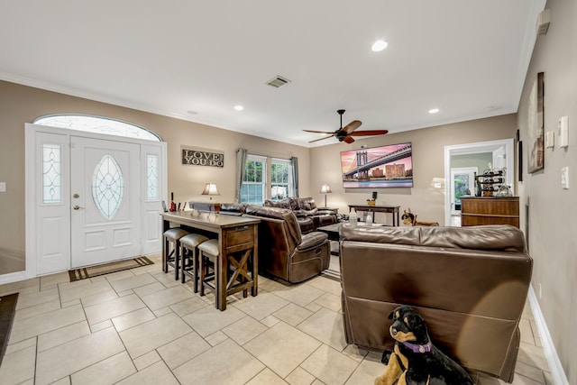 living room featuring ceiling fan, ornamental molding, and light tile patterned floors