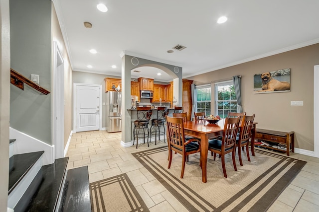 tiled dining room featuring crown molding