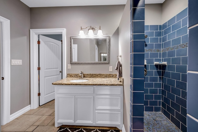 bathroom with tile patterned floors, vanity, and a tile shower