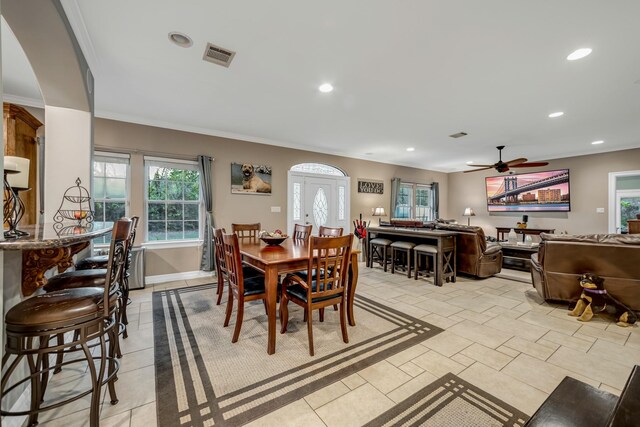 dining room with ceiling fan, light tile patterned floors, and crown molding