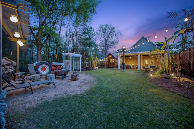 yard at dusk featuring a patio and an outdoor fire pit