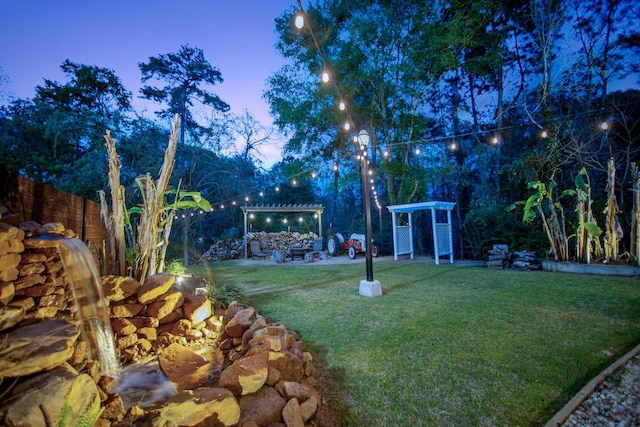 yard at dusk featuring a pergola