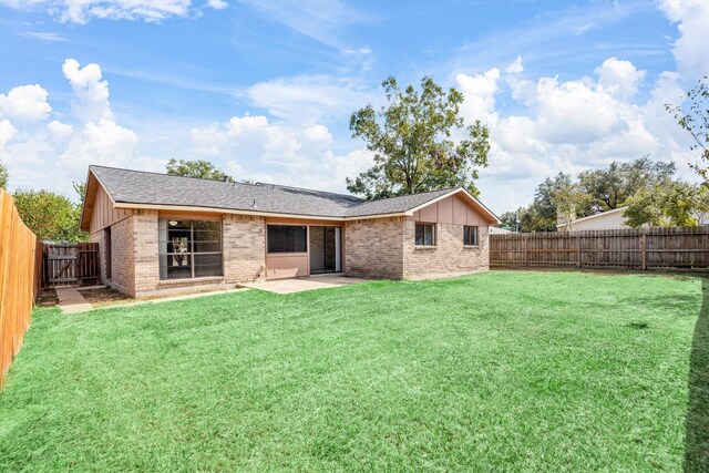 rear view of property with a patio area and a yard