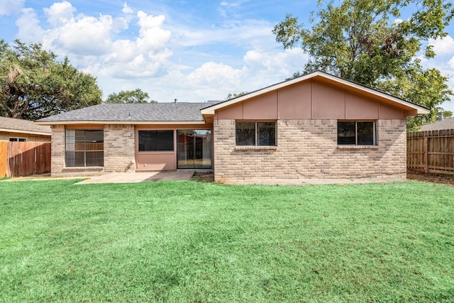 back of property with a patio area and a yard