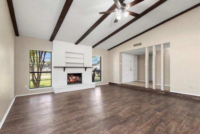 unfurnished living room with dark hardwood / wood-style flooring, lofted ceiling with beams, a brick fireplace, and ceiling fan