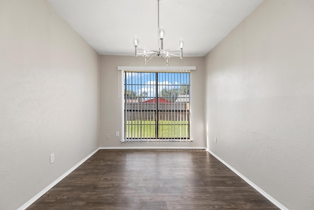 unfurnished dining area featuring dark wood-type flooring and an inviting chandelier