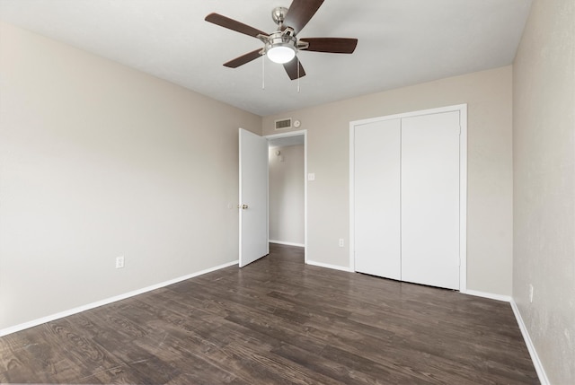 unfurnished bedroom featuring ceiling fan, dark hardwood / wood-style floors, and a closet