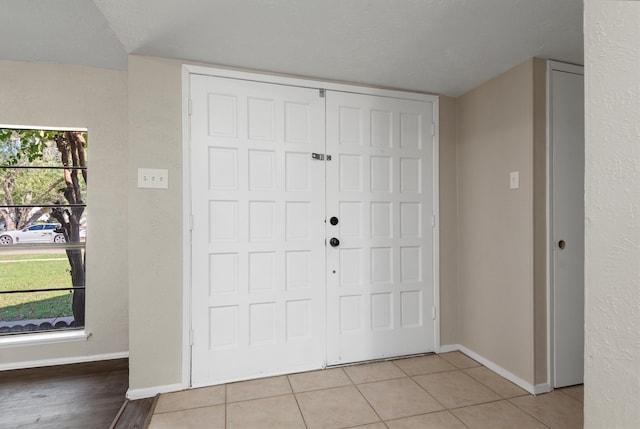 entryway featuring light tile patterned floors and a textured ceiling