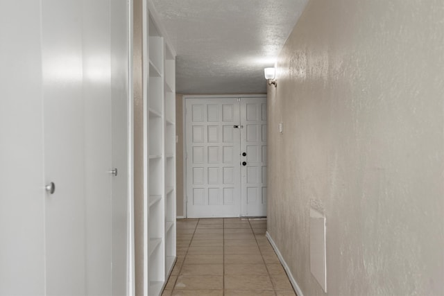 corridor with tile patterned floors and a textured ceiling