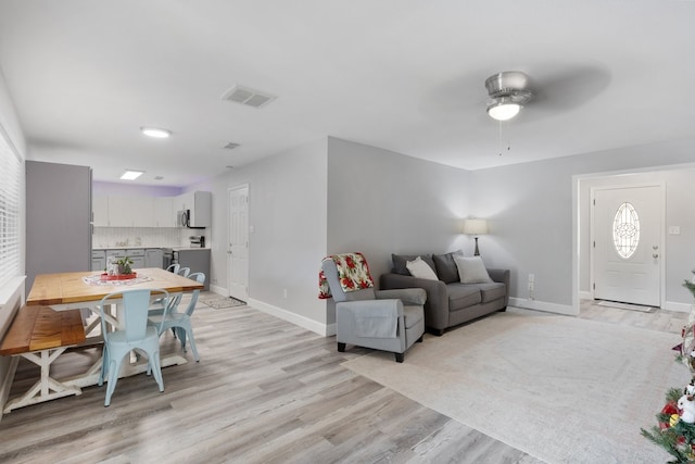 living room featuring ceiling fan and light hardwood / wood-style floors