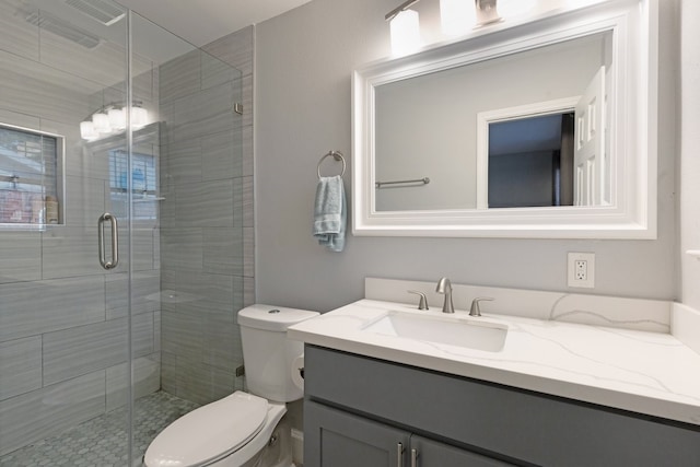 bathroom with vanity, toilet, and an enclosed shower