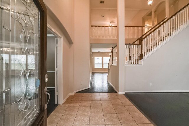 foyer with tile patterned flooring and a towering ceiling