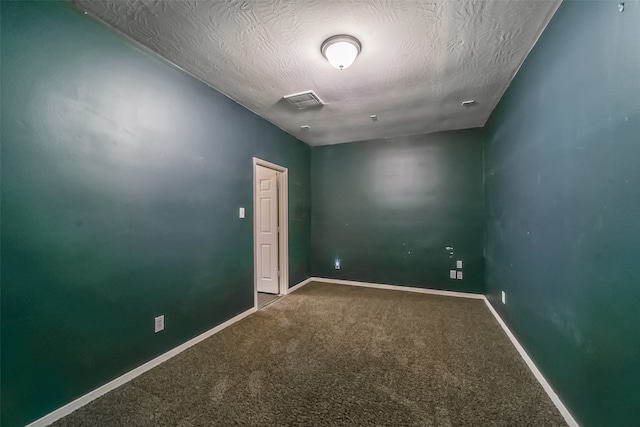 spare room with carpet flooring and a textured ceiling