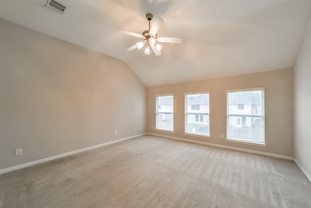 spare room featuring ceiling fan, light colored carpet, and vaulted ceiling